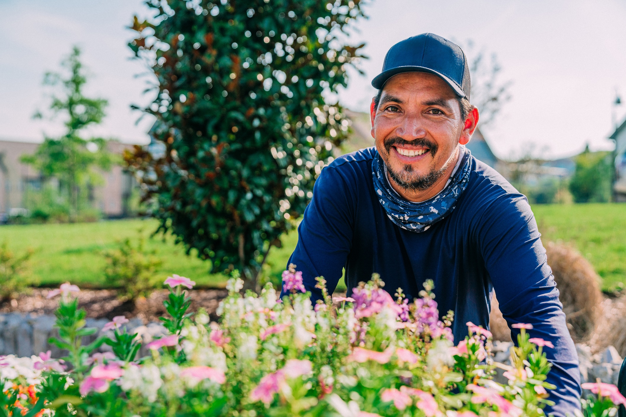 Smiling lawn care provider outside in client yard
